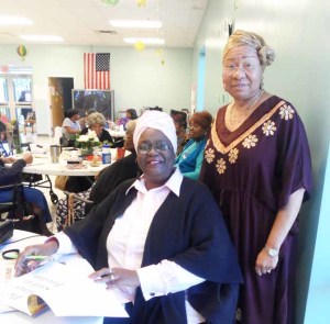 Pictured is author Meltonia Young signing a book for Connie Jackson