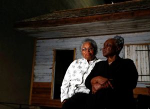 Emily Meggett, left, and Isabell Meggett Lucas sit together at the National Museum of African American History in Washington, Tuesday, April 11, 2017, in front of a slave cabin on display. Lucas was born in the two-room wood cabin that dates to the 1850's. It is believed to be one of the oldest preserved slave cabins in the U.S.  