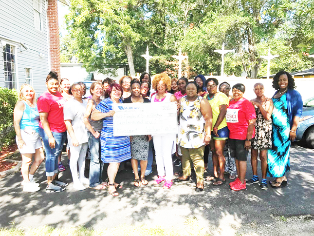 Shown in the photo accepting the Wellcare grant is Beverly McClain, her staff and workshop attendees.